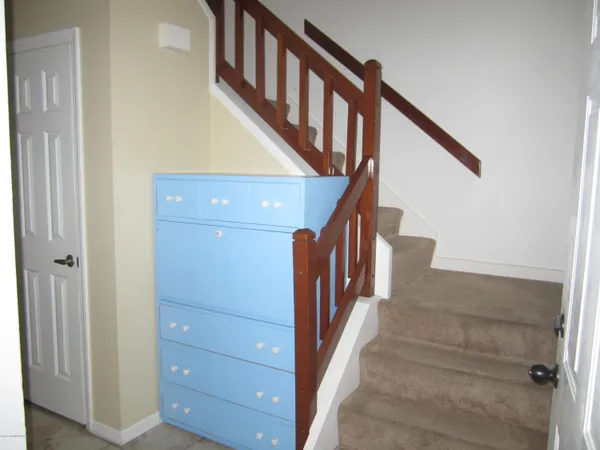 a view of staircase with lots of frames on wall and a window