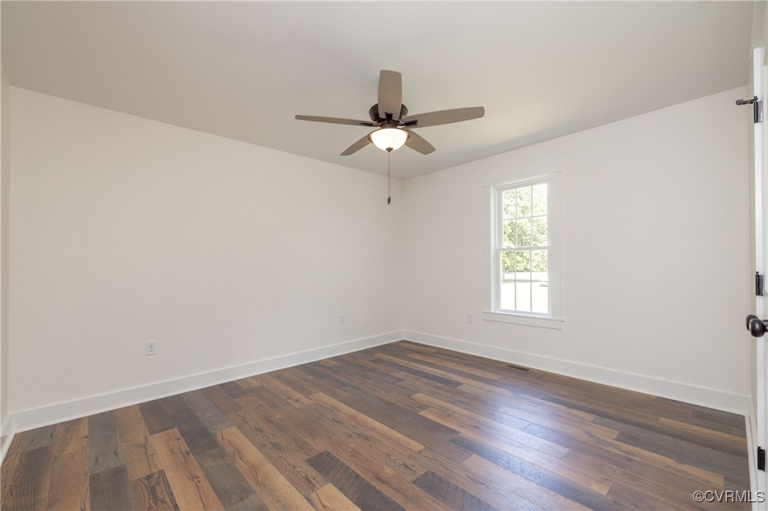 1304 Trimmers Shop Rd Point West Point, VA 23181 - Photo 9 of 12 an empty room with wooden floor ceiling fan and windows