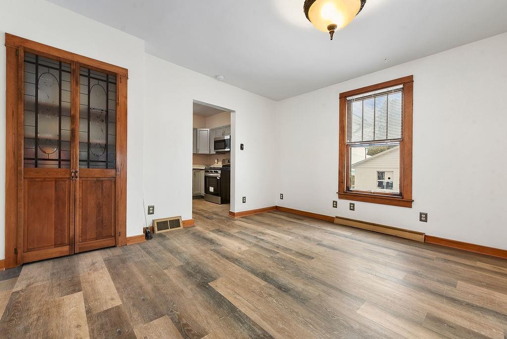 3518 7th Avenue Beaver Falls, PA 15010 - Photo 9 of 28 a view of an empty room with wooden floor and a window