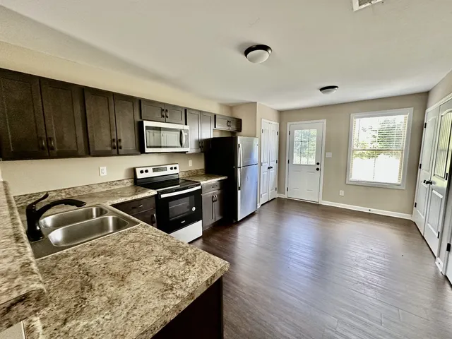 a kitchen with granite countertop a stove and a sink