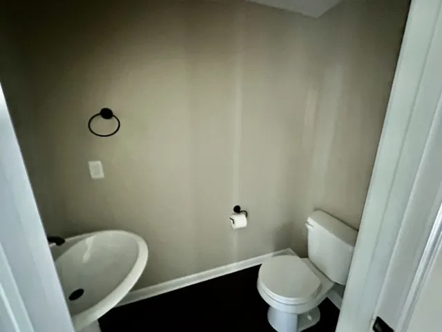 a white toilet sitting next to a bathroom sink and vanity