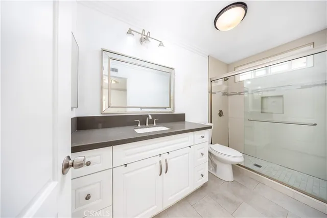 a bathroom with a toilet sink double vanity and mirror