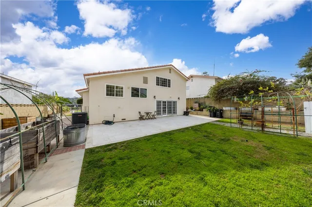 a view of a backyard with couches under an umbrella