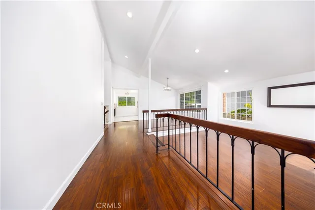 a view of a hallway with wooden floor and stairs