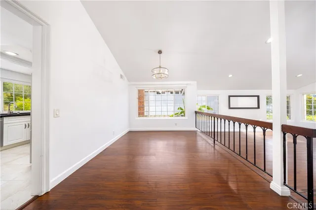 a view of a hallway with wooden floor and windows