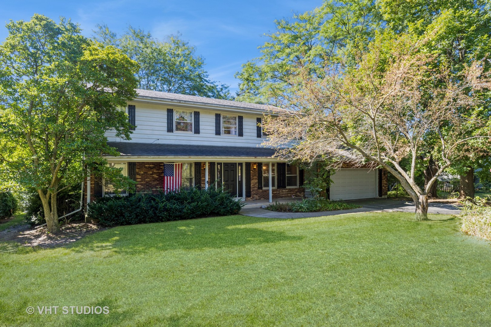 a front view of a house with a yard and trees