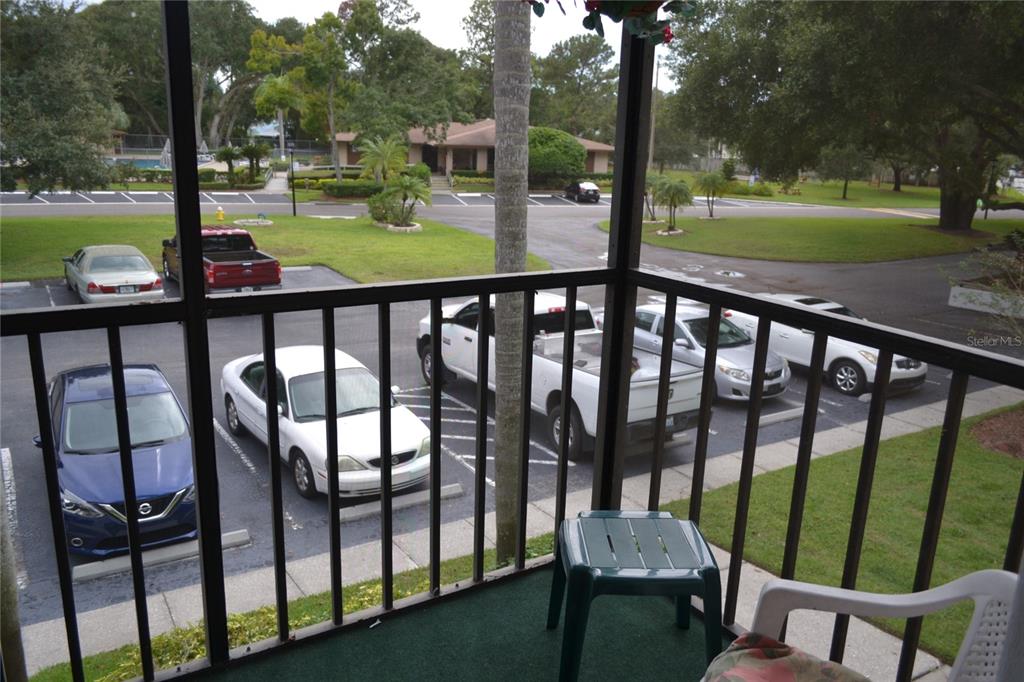 a view of a patio with lawn chairs floor to ceiling window and a yard with wooden fence