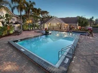 a view of a swimming pool with lawn chairs under an umbrella