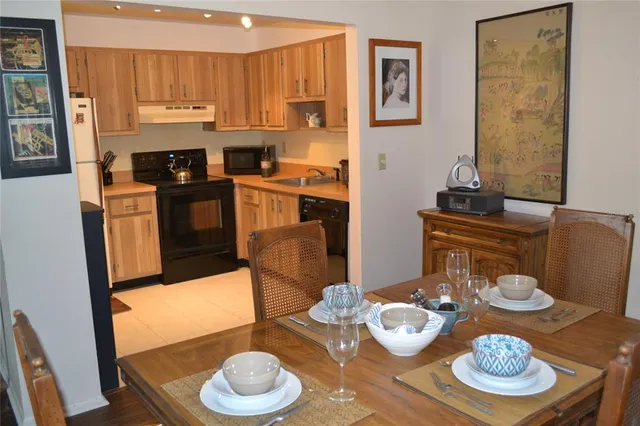 a kitchen with stainless steel appliances granite countertop a dining table and chairs