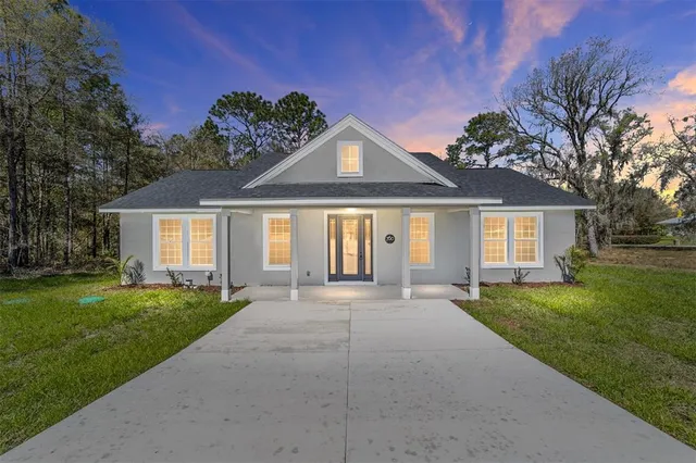 a front view of a house with a garden and trees