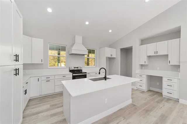 a large white kitchen with cabinets