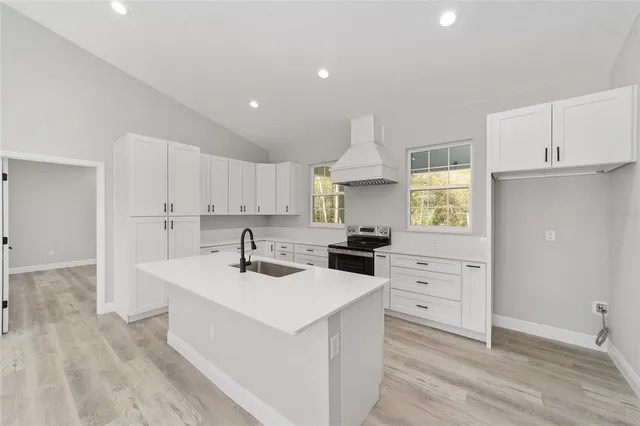 a kitchen that has a sink a stove and window