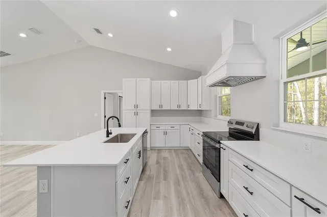 a kitchen with granite countertop a sink a counter space appliances and cabinets