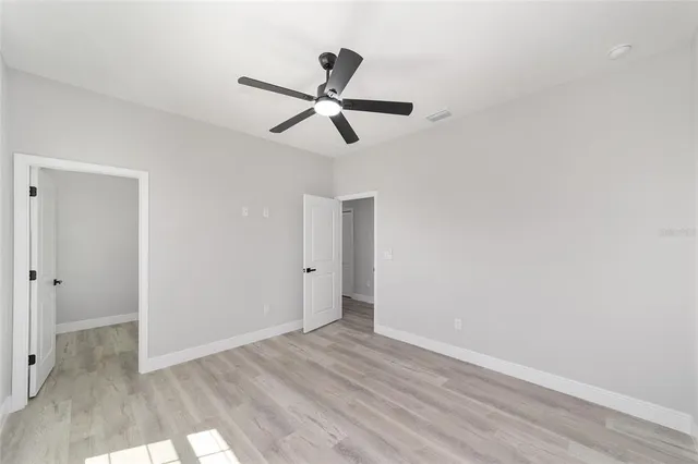 a view of a room with wooden floor and ceiling fan