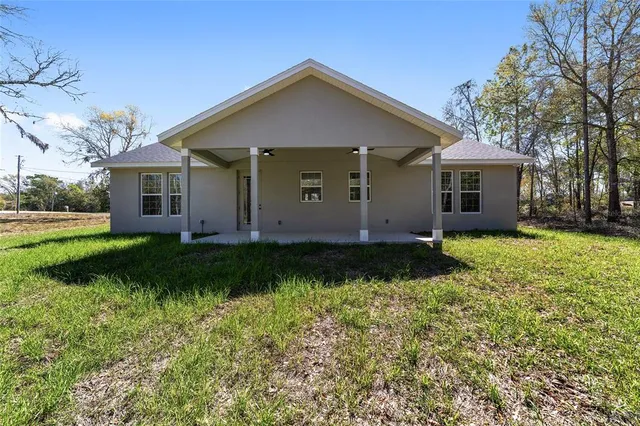 a view of a house with yard and sitting area