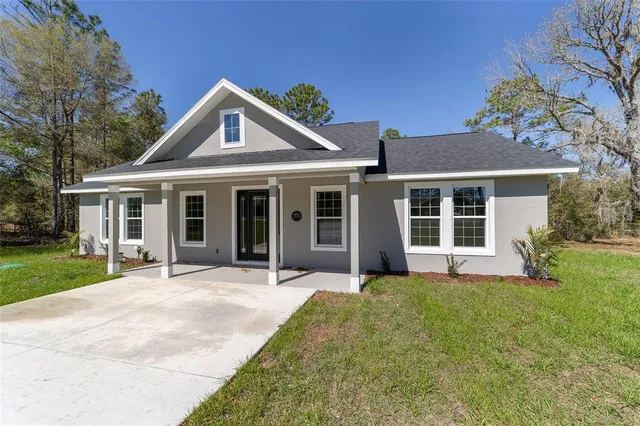 a front view of a house with a yard and porch