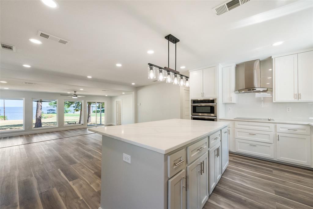 a kitchen that has a lot of white cabinets and wooden floor