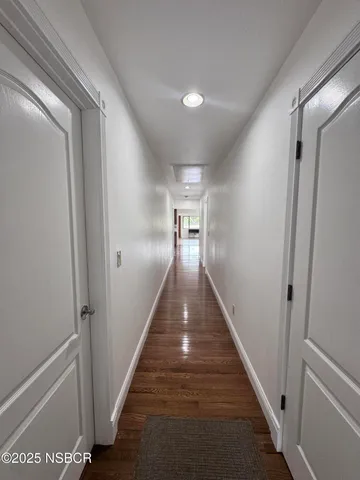 a view of a hallway with wooden floor