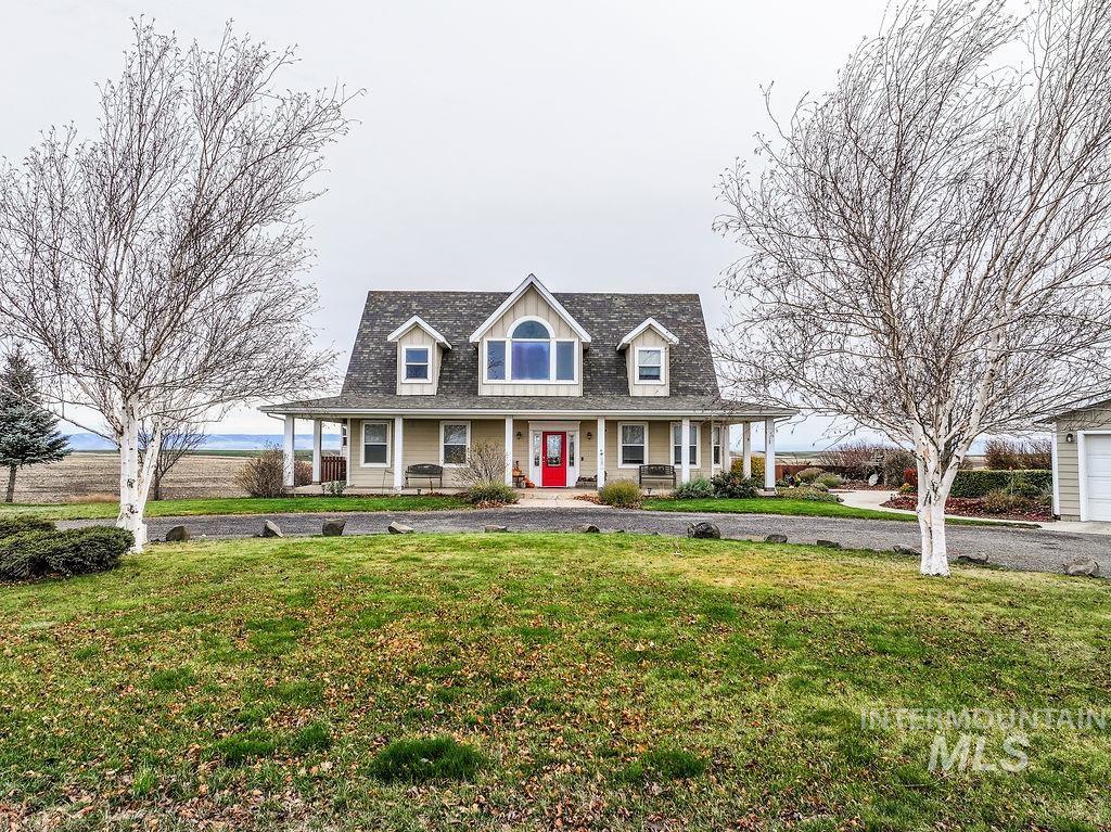 View of front facade featuring covered porch and a front lawn