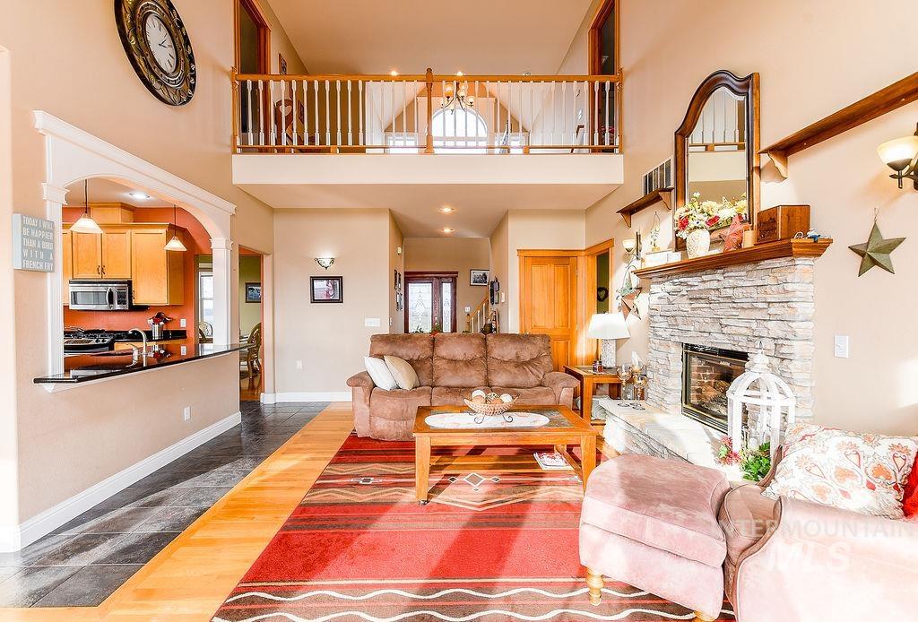 18072 Central Grd Genesee, ID 83832 - Photo 11 of 50 Living area featuring arched walkways, a fireplace, dark wood-style flooring, a towering ceiling, and ornate columns