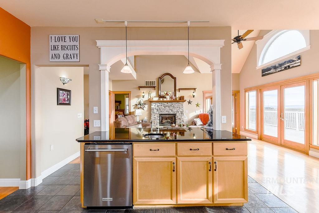 18072 Central Grd Genesee, ID 83832 - Photo 14 of 50 Kitchen with dishwasher, ornate columns, light brown cabinets, a stone fireplace, and high vaulted ceiling