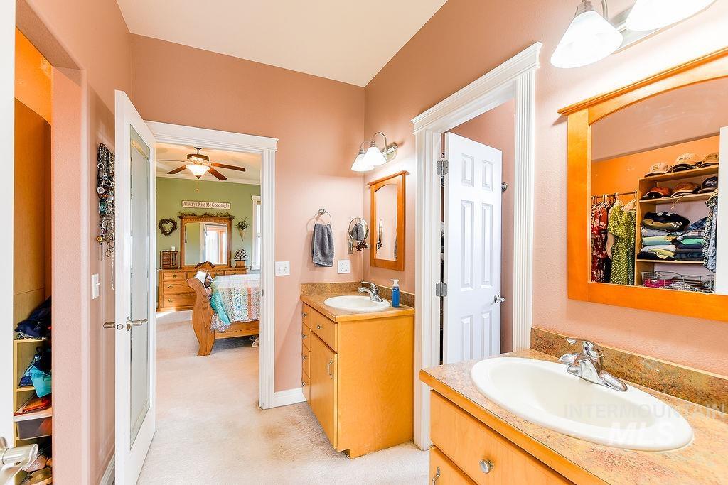 18072 Central Grd Genesee, ID 83832 - Photo 26 of 50 Bathroom with a spacious closet, two vanities, light carpet, ceiling fan, and ensuite bath