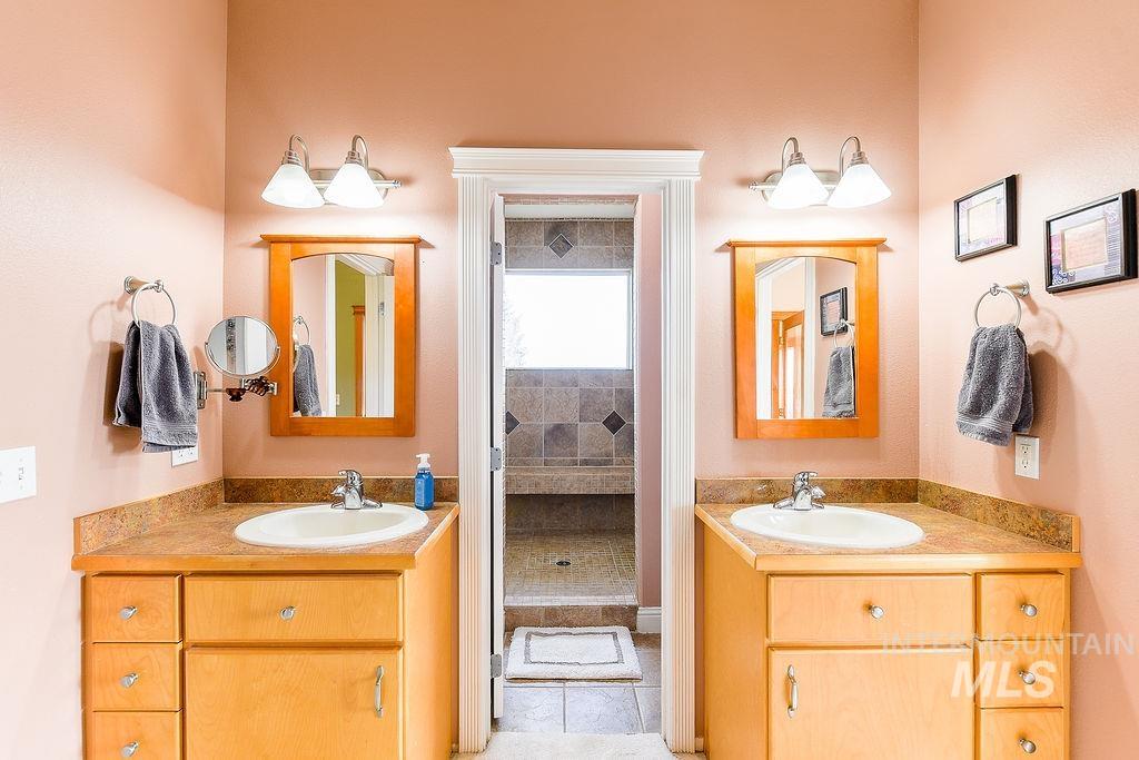 18072 Central Grd Genesee, ID 83832 - Photo 27 of 50 Full bath featuring two vanities, light tile patterned flooring, and a shower stall