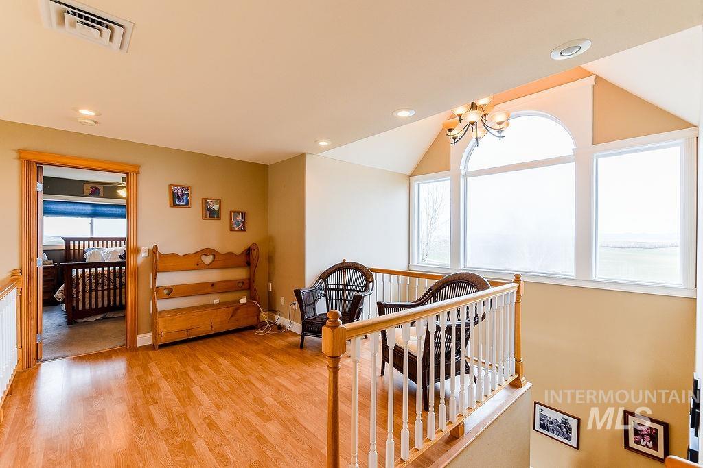 18072 Central Grd Genesee, ID 83832 - Photo 29 of 50 Hallway with an upstairs landing, light wood-style flooring, a chandelier, and recessed lighting
