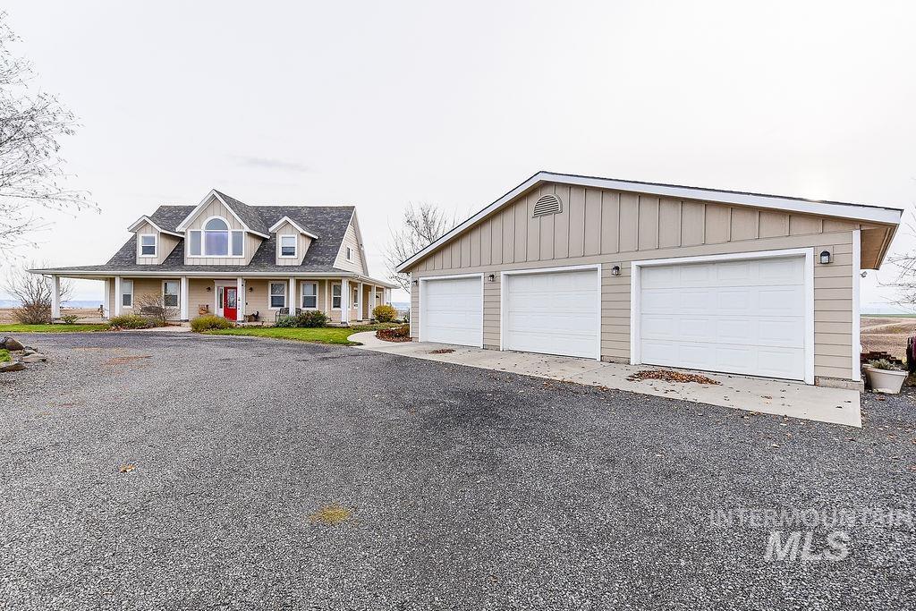 18072 Central Grd Genesee, ID 83832 - Photo 42 of 50 View of front of house featuring a porch, a detached garage, an outdoor structure, and board and batten siding