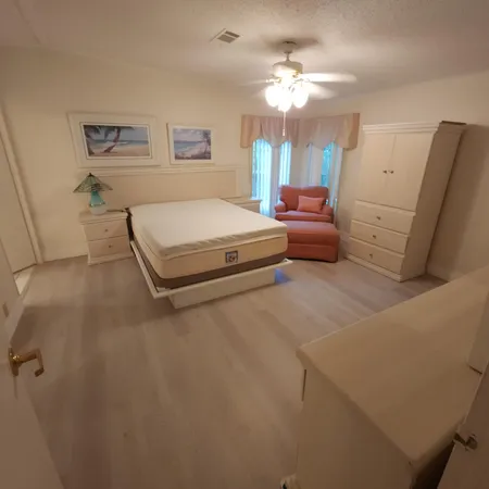 a spacious bedroom with a bed and a chandelier