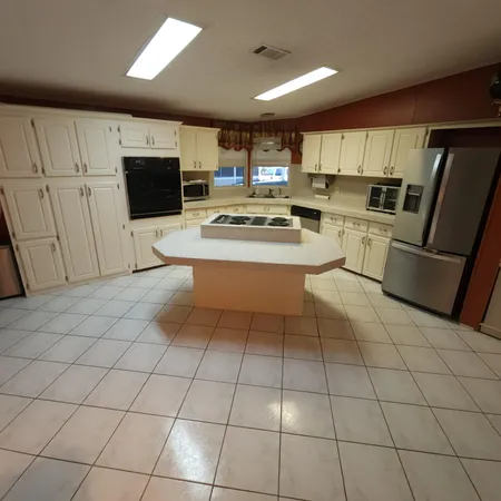 a kitchen with stainless steel appliances a refrigerator and a stove top oven