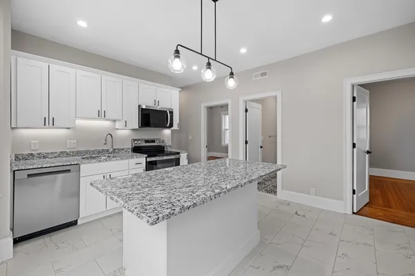 a kitchen with granite countertop a sink and stainless steel appliances