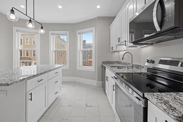 a kitchen with granite countertop a sink stainless steel appliances and cabinets