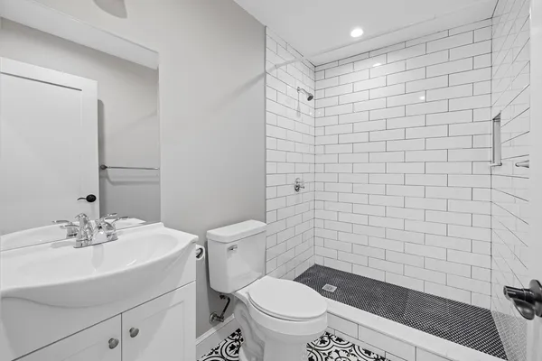 a bathroom with a sink a toilet and shower