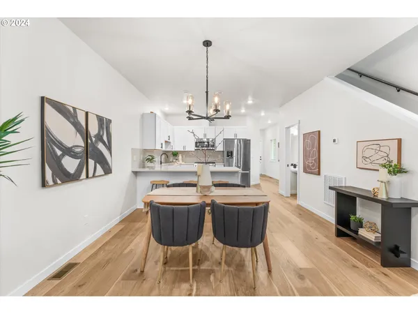 a view of a dining room with furniture a chandelier and wooden floor