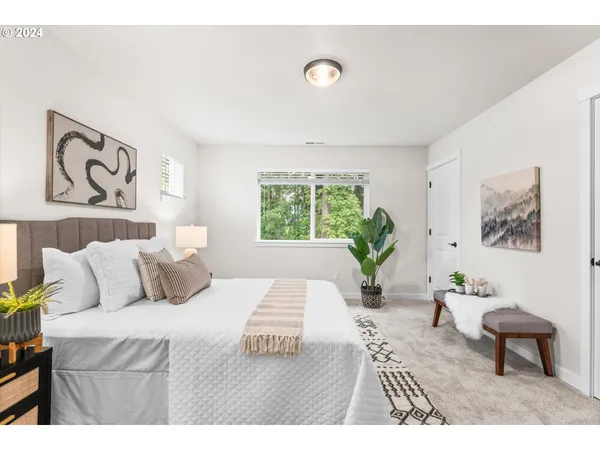 a bedroom with a large bed and a potted plant