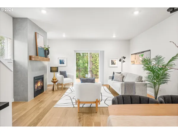a living room with furniture a fireplace and a potted plant