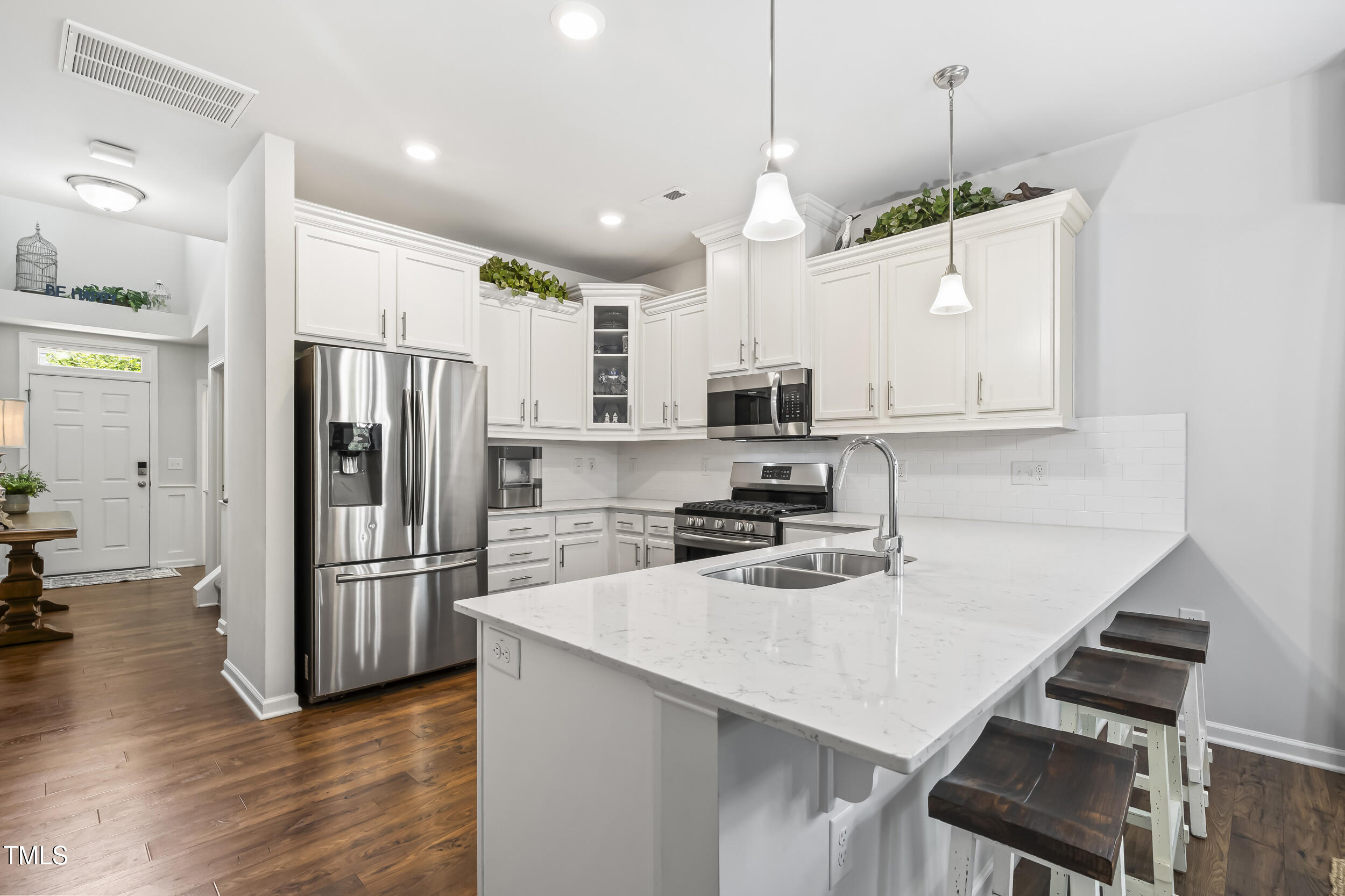 6050 Beale Loop Raleigh, NC 27616 - Photo 6 of 35 a kitchen with kitchen island a refrigerator stove microwave and cabinets with wooden floor