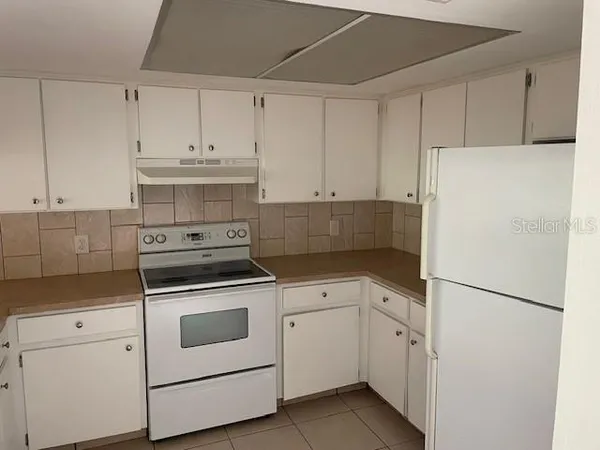a kitchen with white cabinets and white appliances