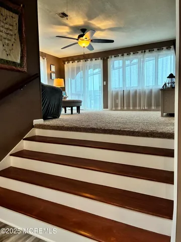 a bedroom with a bed a mirror on the dresser and a chandelier