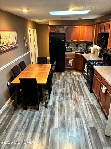 a room with stainless steel appliances kitchen island granite countertop a refrigerator stove and sink