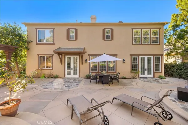 a view of a brick house with chairs and table in a patio