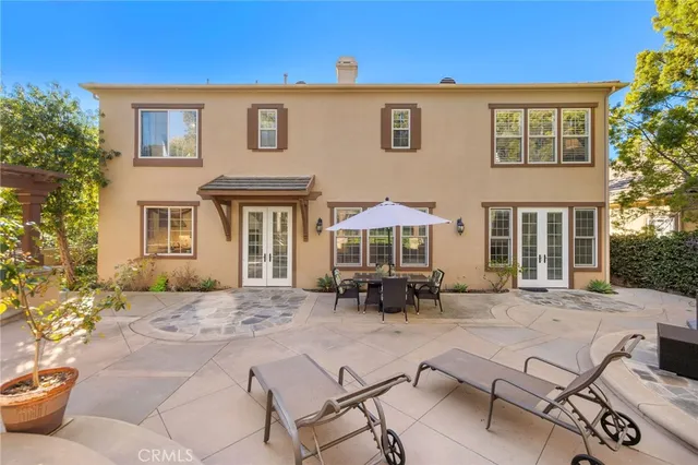 a view of a brick house with chairs and table in a patio