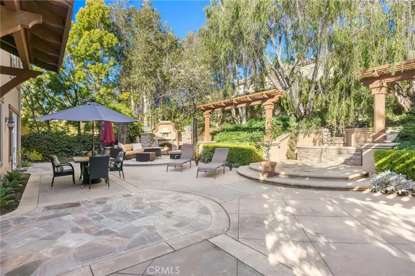 a view of a chairs and table under an umbrella in backyard
