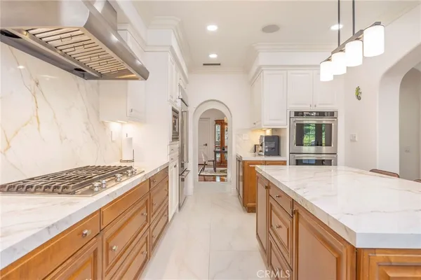 a large kitchen with stainless steel appliances granite countertop a stove and cabinets