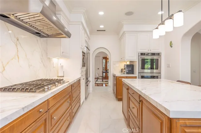 a large kitchen with stainless steel appliances granite countertop a stove and cabinets