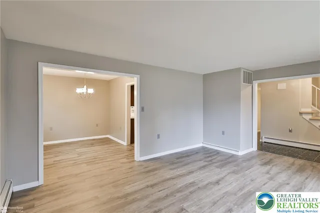 a view of a livingroom with a chandelier wooden floor and a chandelier