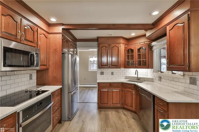 a kitchen with stainless steel appliances granite countertop a stove microwave and refrigerator