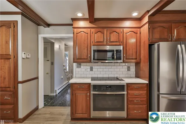 a large kitchen with a lot of counter space and wooden floor