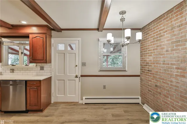 a hallway with wooden floor a fireplace and entryway